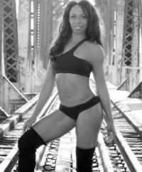 black and white picture of trainer Nicole Steen standing on train tracks wearing a 2 piece athletic outfit